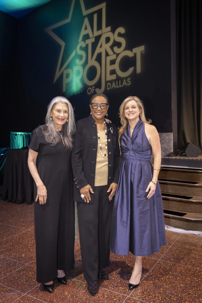 cynt posing on stage with two people