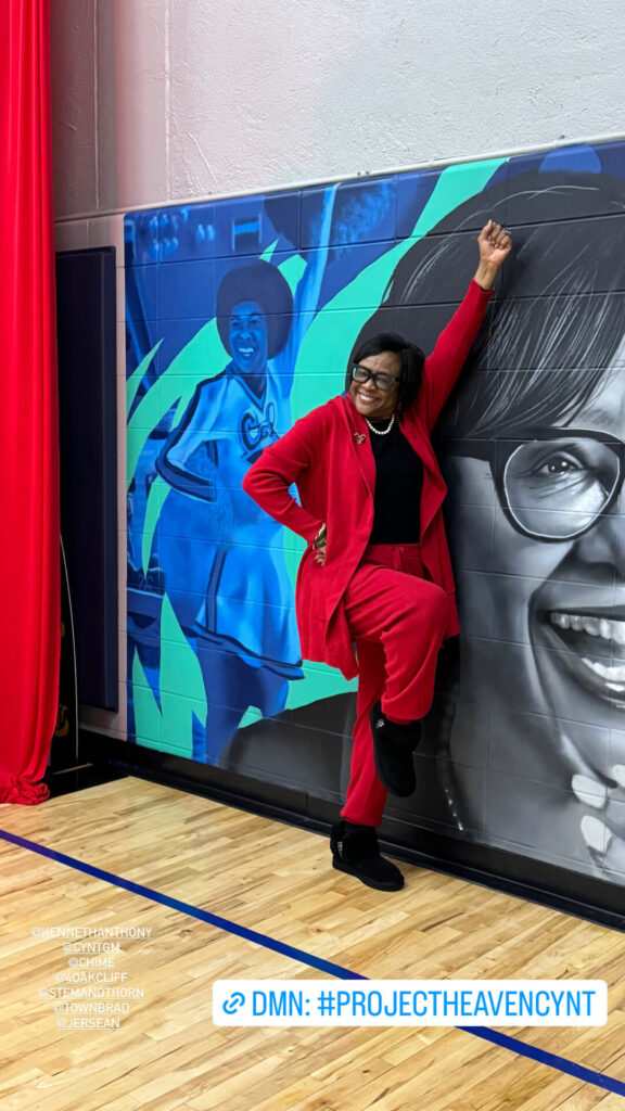 Cynt in front of a mural